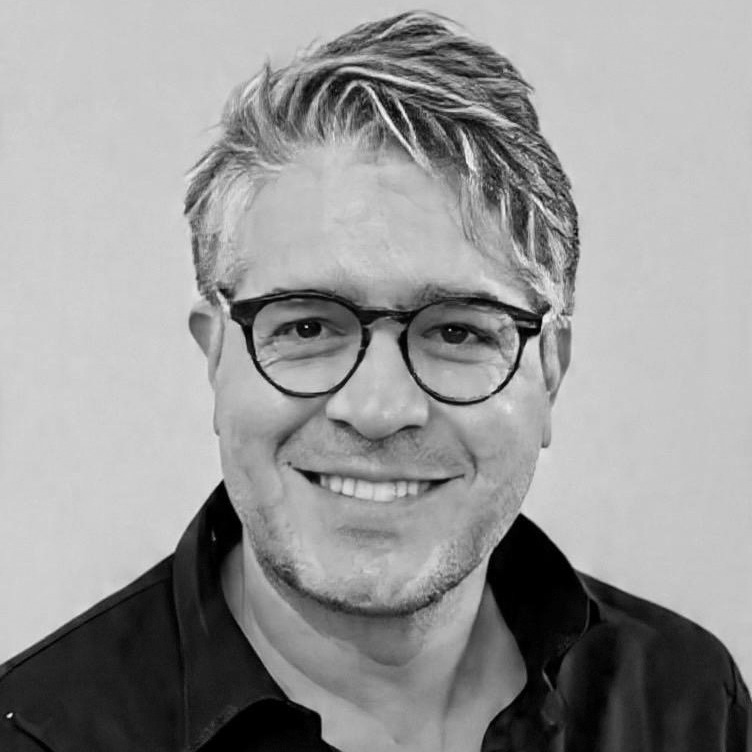 Harry Jupp - Complyport - Your Trusted Partner in Governance, Risk, Compliance & Technology - Complyport - Your Trusted Partner in Governance, Risk, Compliance & Technology Smiling man with gray hair and round glasses wearing a black collared shirt.
